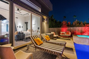 Poolside loungers and outdoor seating illuminated after sunset