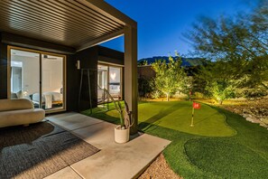 Shaded outdoor seating overlooking the private landscaped lawn