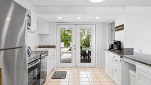 A modern kitchen with white cabinetry, a stainless steel refrigerator, and a coffee maker on the counter. - Pool Party South · 3BR · Pool & Spa · Updated Jan 2025 (Holmes Beach)