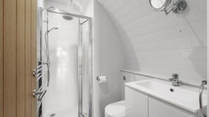 A modern bathroom with a shower, toilet, and sink.