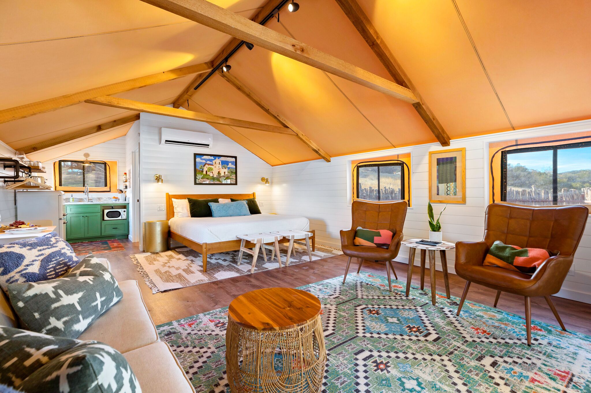 Une chambre confortable aménagée en mezzanine, avec un lit, un coin salon et une kitchenette.