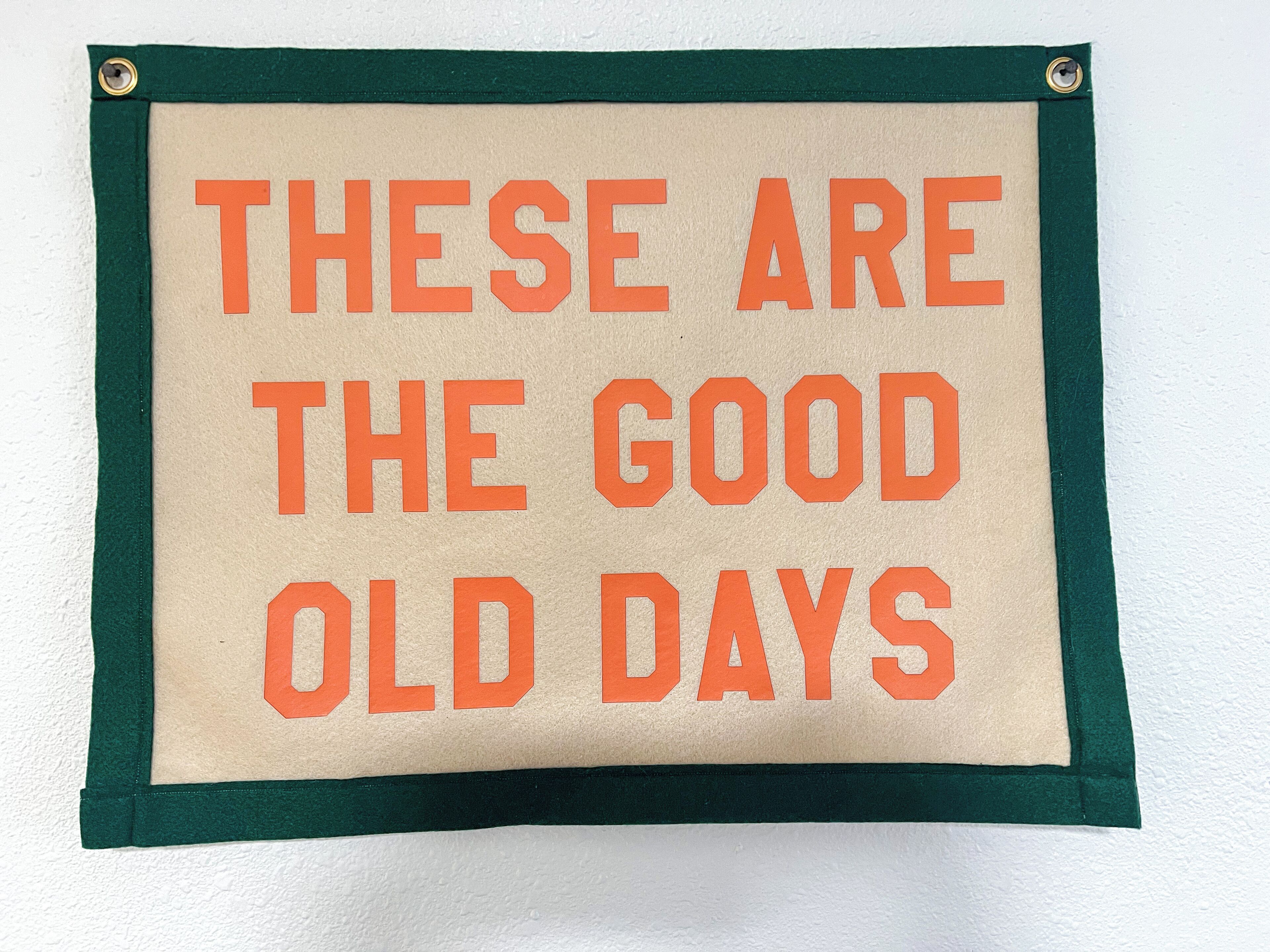 Ein Schild mit der Aufschrift 'Das sind die guten alten Zeiten', das an einer Wand befestigt ist.