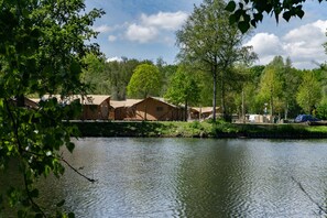 A lakeside campsite with multiple cabins, a dock, and a car parked nearby. - EuroParcs Het Amsterdamse Bos (Amstelveen)