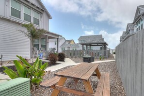 A residential area with houses, a wooden fence, a picnic table, and a gazebo. - The best vacation memories are made at the beach! Golf cart available for rent, (Port Aransas)