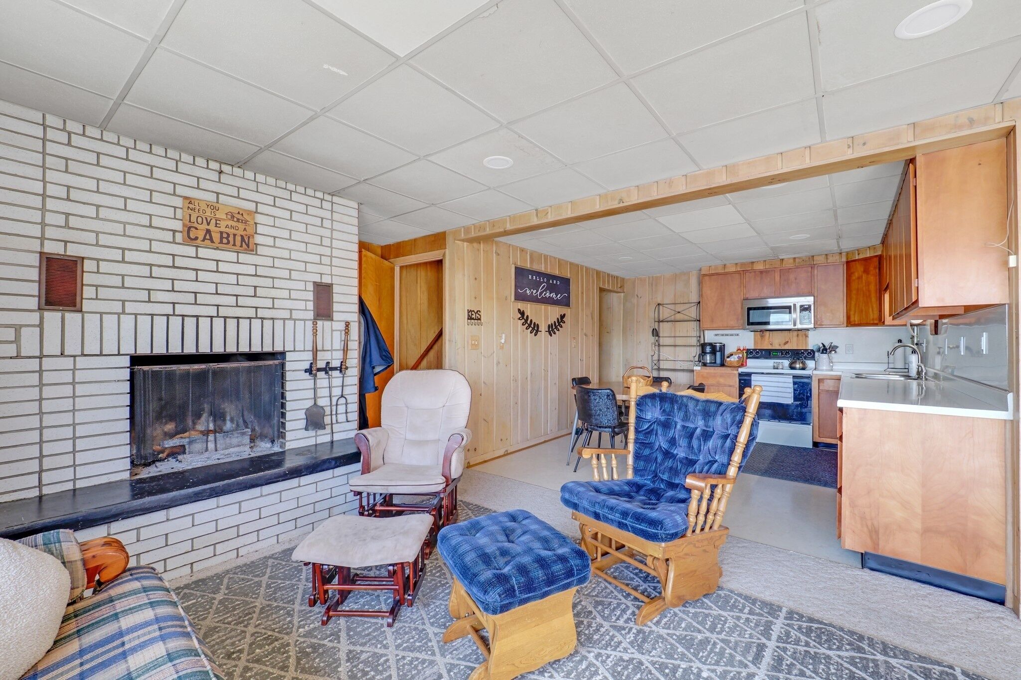 A cozy living room with a fireplace, a kitchen area, and a dining space.