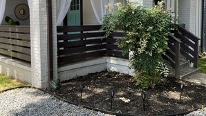 A house with a covered porch, a staircase, and a small garden area. - Family-Friendly 2BR Bungalow | Falcons • Concerts • Pool Access | Botel (Atlanta)