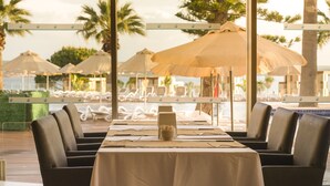 Un restaurant offrant une vue sur la piscine et les palmiers.