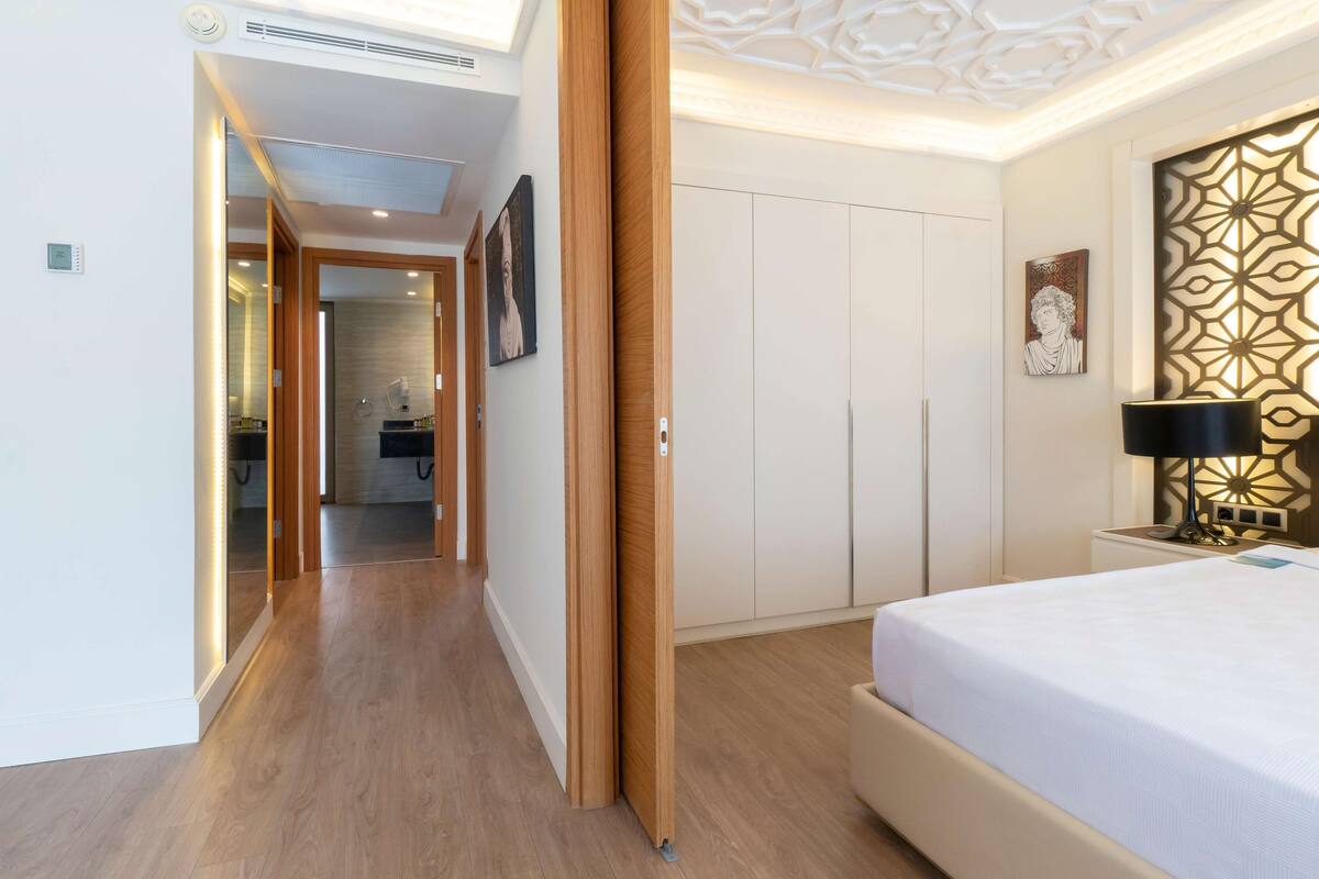 A hotel room with a bed, wardrobe, and a bathroom visible through an open door.