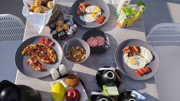 Una mesa con una abundante variedad de alimentos y condimentos para el desayuno.