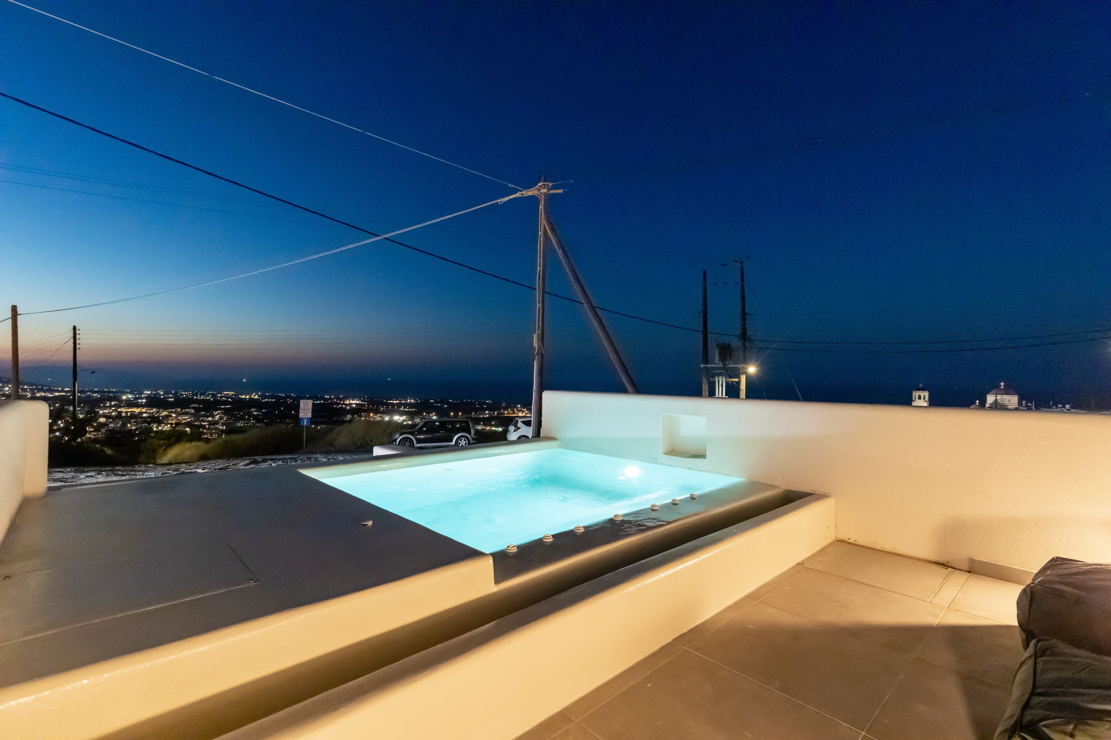 A rooftop pool with a city view at dusk.