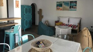 Ein Wohnzimmer mit einer Couch, einem Couchtisch und einem Essbereich mit Stühlen und einem Tisch.
