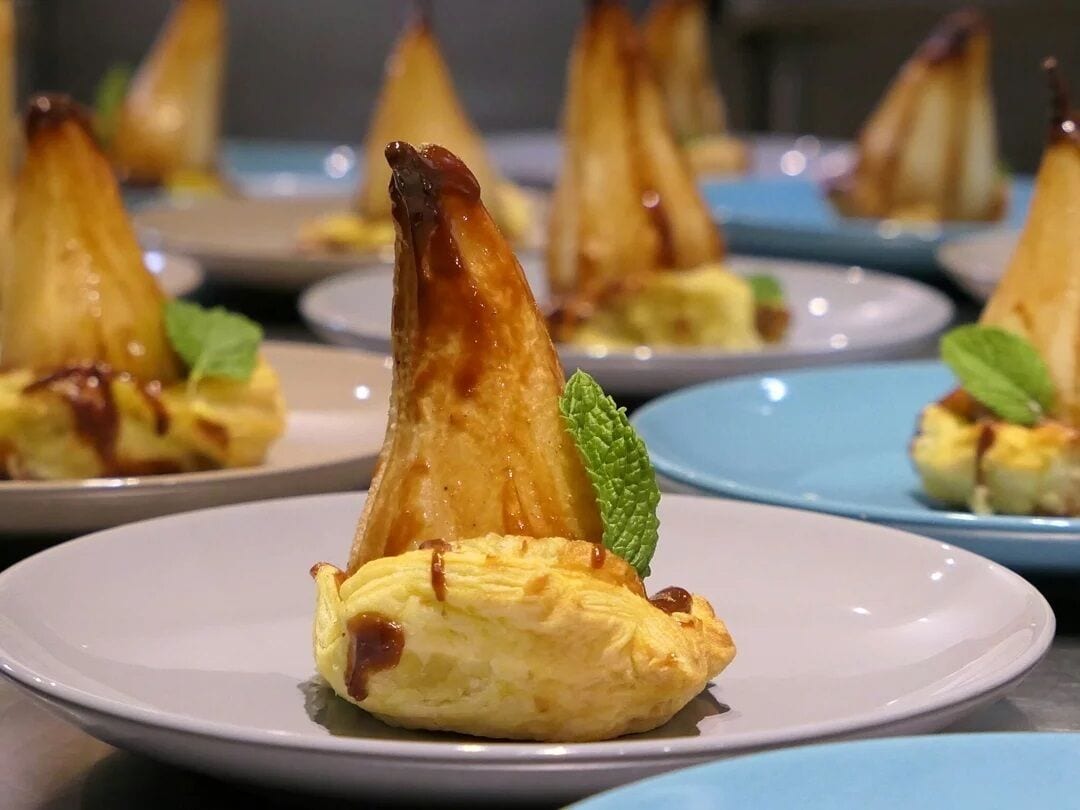 Presentación de postres con hojaldres triangulares en platos.