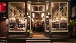A public house with a wooden interior, multiple seating areas, and a visible exit sign. - Fillmore Loft at Public House on Elk Ave (Crested Butte)