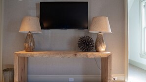 Un banco de madera con dos lámparas, un televisor y un globo decorativo.