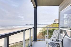 A balcony with a view of the beach and ocean.