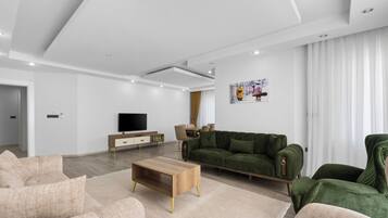 Een moderne woonkamer met een bank, salontafel en televisie.