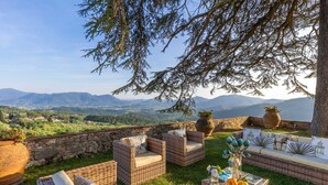 Ein Außenbereich mit Korbmöbeln und Blick auf die Landschaft.