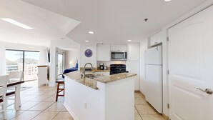 A modern kitchen with white cabinets, a granite countertop, and stainless steel appliances. - Fifth Floor Villamare unit with lots of updates! (Hilton Head)