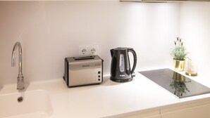 A kitchen with a sink, a toaster, a kettle, and a small plant on the countertop. - FLH Restauradores Modern Studio II (Lisbon)
