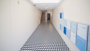 A hallway with lockers, a patterned floor, and a staircase leading to another area. - FLH Restauradores Modern Studio II (Lisbon)