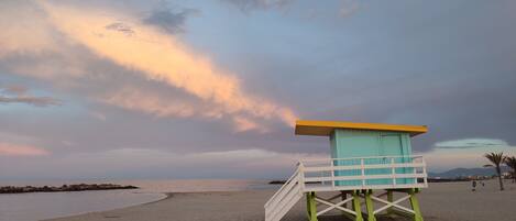 A lifeguard tower on a beach with a staircase leading up to it.