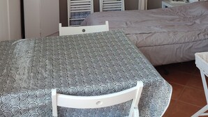 A compact bedroom with a bed, a desk with a chair, a ceiling fan, and a TV on a cabinet. - STUDIO WITH SEA VIEW TERRACE FACING THE BEACH (Le Barcarès)