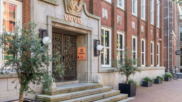 Un edificio con fachada de piedra, un cartel que dice "vievia 23" y un conjunto de escalones que conducen a la entrada.