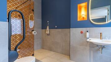 Un baño moderno con inodoro, ducha y lavamanos.