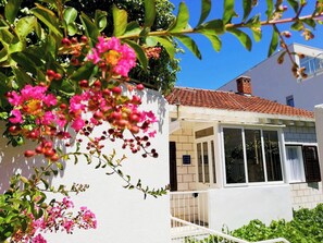 Un bĂątiment blanc avec un toit en tuiles, un balcon et une fenĂȘtre.