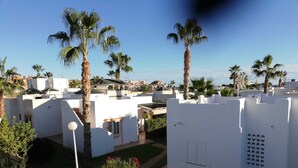 A residential area with white buildings, palm trees, and a clear sky. - Beautiful, cozy vacation home on the Costa Calida, Andalusia 5 min. to the beach (San Juan de los Terreros Andalucia)