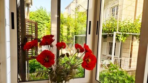 A window with a view of a garden and a building. - Insideout Apartment (Dubrovnik)
