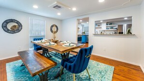 Un comedor con una mesa de madera, sillas azules y un tapete azul.