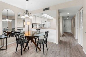 A modern kitchen with white cabinets, a microwave, and a refrigerator. - Stunning Second Floor Park Shore Resort Unit 223 (Naples)