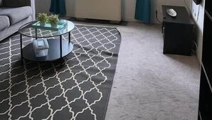 A modern living room with a sofa, a coffee table, a radiator, and a large window with curtains. - Heart of ATL Downtown  1B1B  City View  Cozy Condo (Atlanta)
