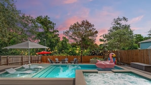 En baghave med swimmingpool, jacuzzi og en flydende flamingo.