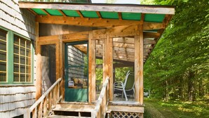 A wooden deck with a staircase leading to a covered porch. - Spacious UP Retreat with Sauna & Direct Trail Access (Wetmore)