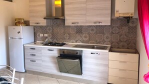 A modern kitchen with light wood cabinets, a built-in oven, a gas stove, and a stainless steel sink. - TWO-ROOM APARTMENT PIOMBINO MARE 50 MT - 4 PANORAMIC BEDS (Piombino)