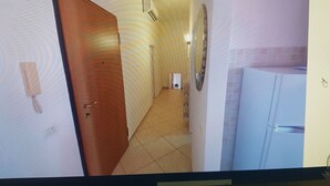 A room with a wooden door, a white cabinet, and a tiled floor. - TWO-ROOM APARTMENT PIOMBINO MARE 50 MT - 4 PANORAMIC BEDS (Piombino)
