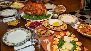 A dining table set with various dishes, including a roasted turkey, salads, and eggs. - Cozy 3 bedroom 2 bath home close to hiking, biking, and Stowe! (Hyde Park)