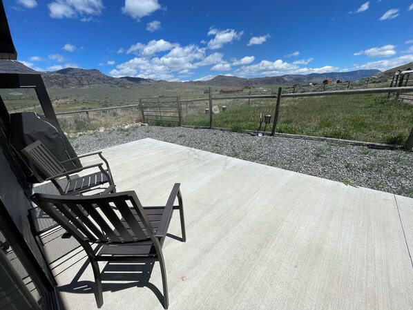 Relax in a serene outdoor space with a tranquil view of rolling hills and distant mountains.