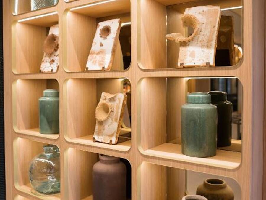 Een houten presentatie met diverse keramieken vazen en kommen.