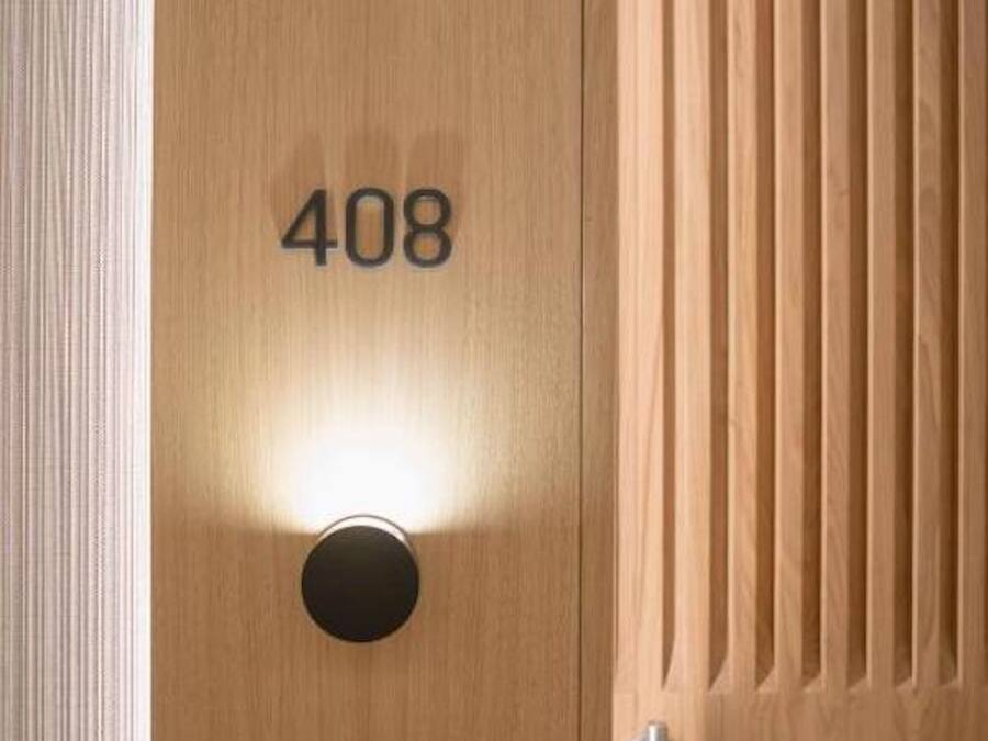A wooden door with the number 408, a round light fixture, and a keyhole.