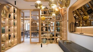A modern interior with wooden shelving displaying various decorative items, a central open space, and a black countertop. - MYR Puerta Serranos (Valencia)