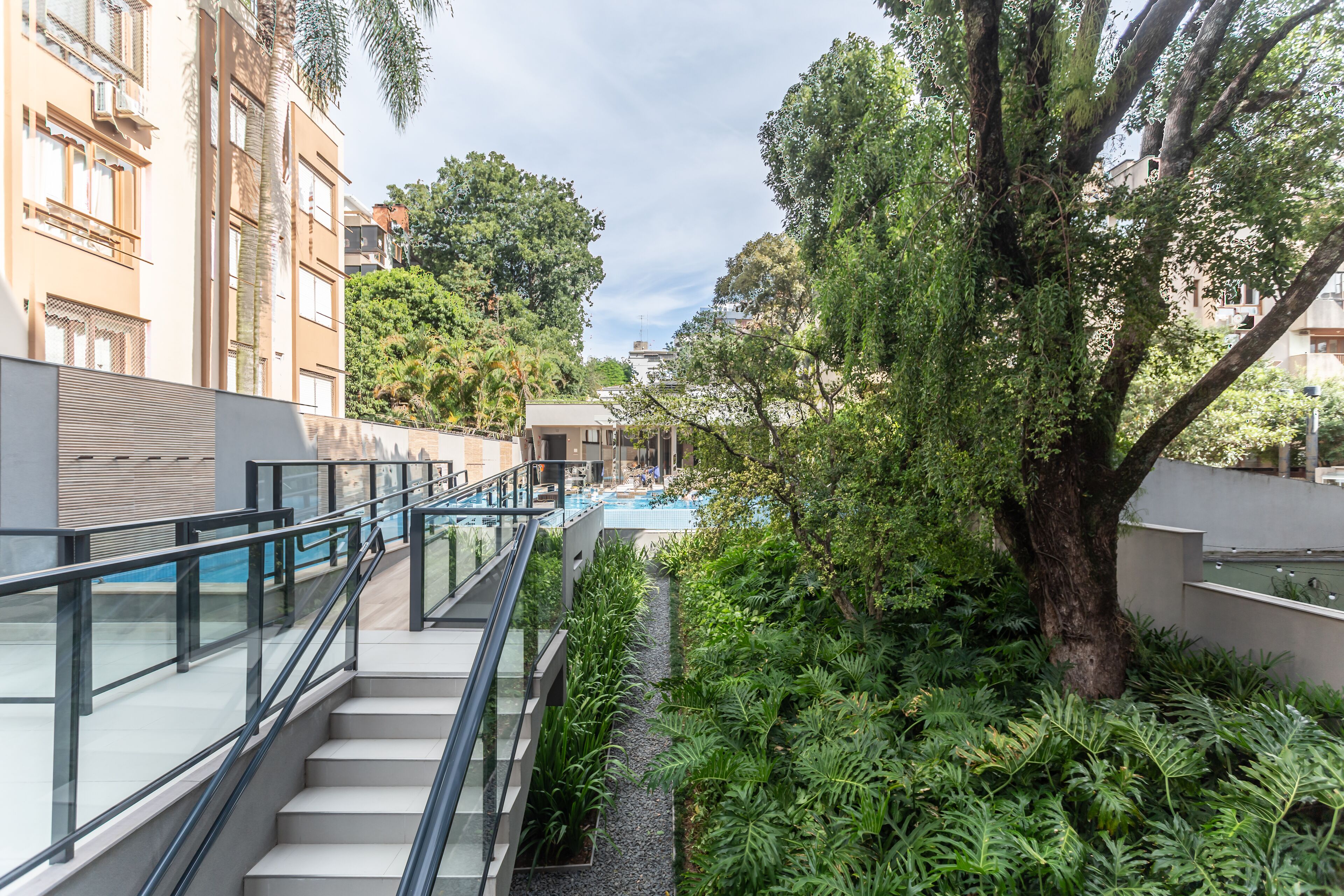 Ein modernes Gebäude mit einer Glasstiege, die zu einer Dachterrasse mit Pool führt.