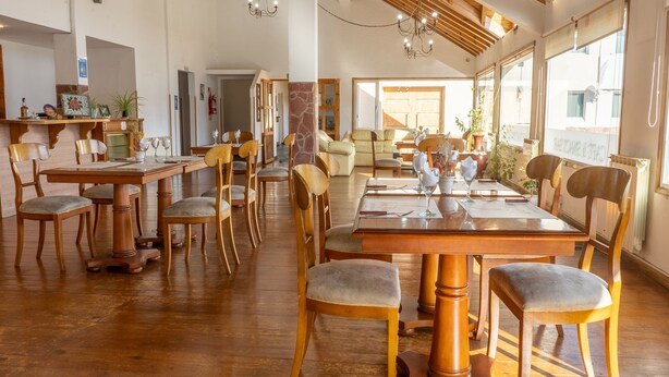 Un comedor amplio con muebles de madera y ventanas grandes.