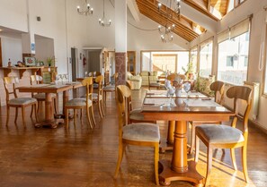 Un comedor amplio con muebles de madera y ventanas grandes.