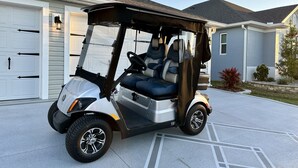 Golfiauton voi nähdä pysäköitynä omakotitalon edessä, talon yhteydessä on autotalli.