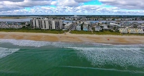 An aerial view of a coastal area with buildings, a beach, and the ocean. - Oceanfront Balcony Views, Pool, STEPS to Beach Restaurants Shops (Wrightsville Beach)