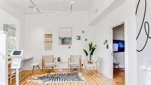 A modern room with wooden flooring, a zebra print rug, and a mounted TV.