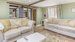 Ein Wohnzimmer mit zwei Sofas, einem Couchtisch und einem Teppich.